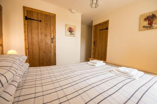 um quarto com uma cama grande com duas toalhas em Badgers Wood em Buxton