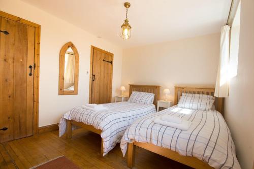 um quarto com 2 camas e um espelho em Badgers Wood em Buxton