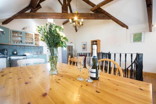 uma garrafa de vinho e dois copos numa mesa de madeira em Badgers Wood em Buxton