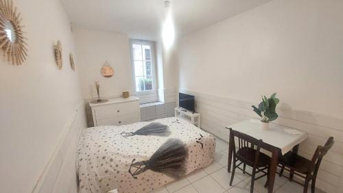 une petite chambre avec un lit et une table dans l'établissement STUDIO MEUBLÉ AU PIED DU CHATEAU, à Lourdes