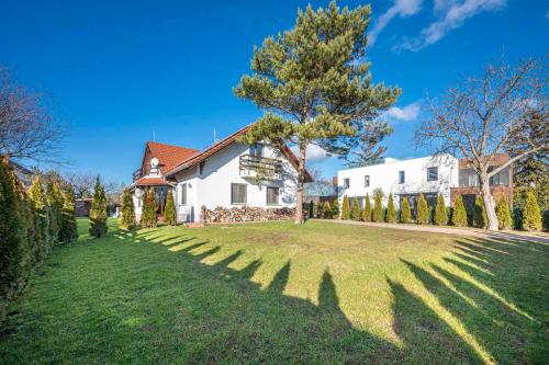 a large white house with a tree in the yard at Panorama Buda in Budapest