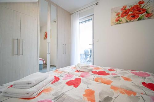 een slaapkamer met een bed met handdoeken erop bij Luxury apartment with swimming pool Ana in Trogir