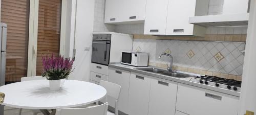 een witte keuken met een tafel en een magnetron bij Fifth Floor in Napels