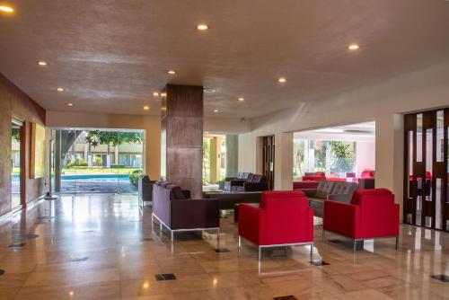 a lobby with red chairs and a pool at Camino Real Guadalajara in Guadalajara