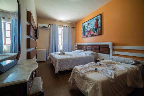 a hotel room with two beds in a room at Hotel Morro dos Conventos in Araranguá