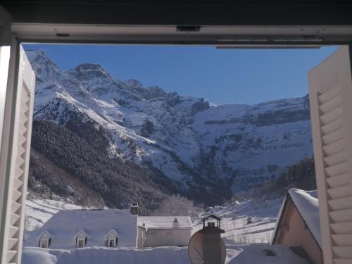 a view of a snow covered mountain from a window at Chambres d'hôtes L'Astazou in Gavarnie