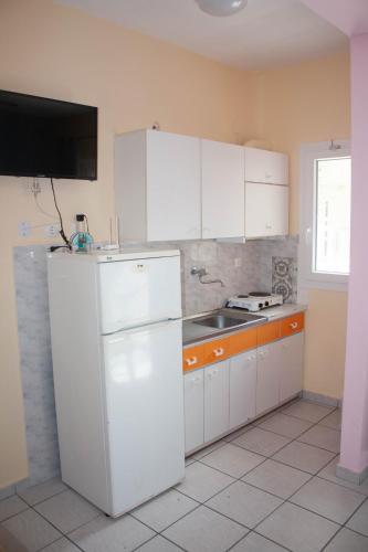 a kitchen with a white refrigerator and a sink at Armonia in Paralia Katerinis