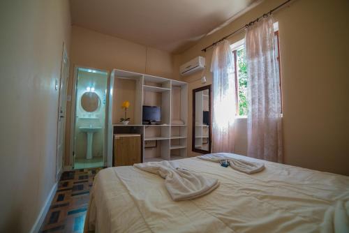 um quarto com uma cama grande e uma janela em Hotel Morro dos Conventos em Araranguá