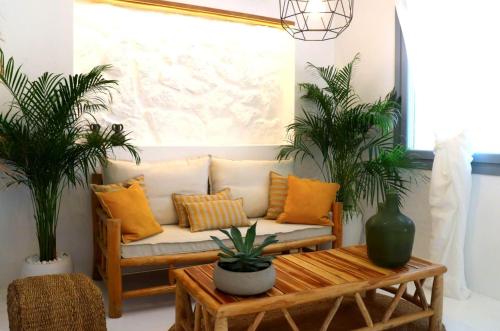 a living room with a couch and two palm trees at The Nine Graces - Kastraki Villas with Private Swimming Pool in Kastraki Naxou
