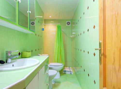 uma casa de banho verde com um WC e um lavatório em Fuengirola playa carina em Fuengirola