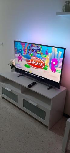 a flat screen tv sitting on top of a entertainment center at Rosyshome102 in Vecindario