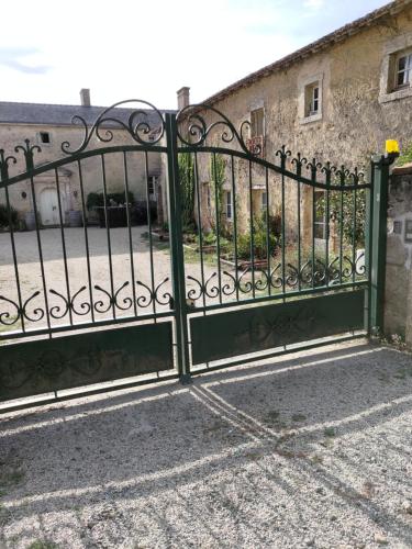 um portão verde em frente a um edifício em Le Manoir de Gâtines em Tigné