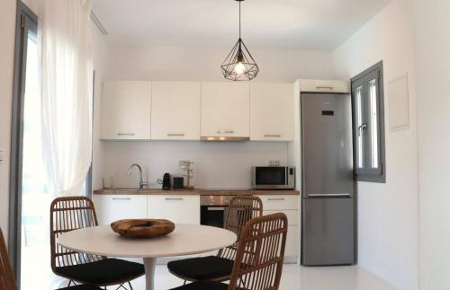 a kitchen with a table with chairs and a refrigerator at The Nine Graces - Kastraki Villas with Private Swimming Pool in Kastraki Naxou