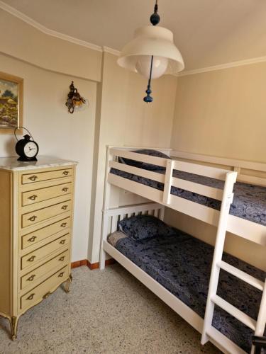a bedroom with two bunk beds and a dresser at Apartamento en la torre de S`Abanell in Blanes