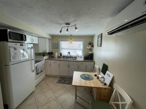 uma cozinha com um frigorífico branco e uma mesa em Cozy Beach Rental 1B/1B em St. Pete Beach