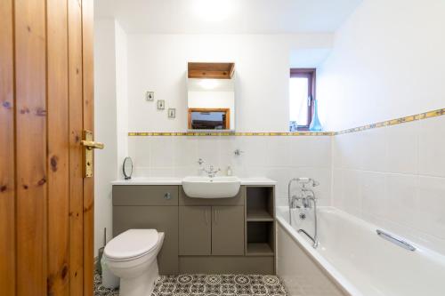 een badkamer met een toilet, een wastafel en een bad bij The Oast House - farm stay apartment set within 135 acres in Bromyard