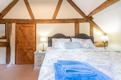 a bedroom with a large bed with a wooden headboard at The Oast House - farm stay apartment set within 135 acres in Bromyard