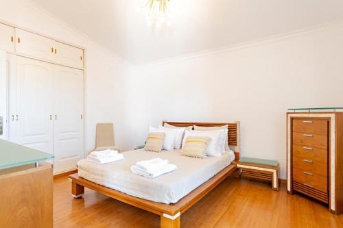 Suite Bela Vista في تافيرا: غرفة نوم مع سرير وملاءات بيضاء وخزانة