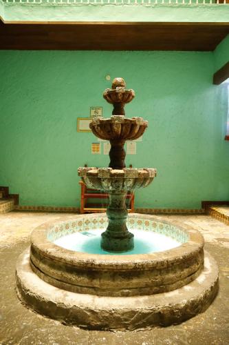 a fountain in the middle of a room with a green wall at Hotel Juarez in Mexico City