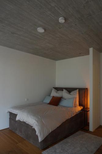 a bedroom with a large bed with a wooden ceiling at Schönes Neubau Serviced-Apartment mit Parkplatz in Bruchsal