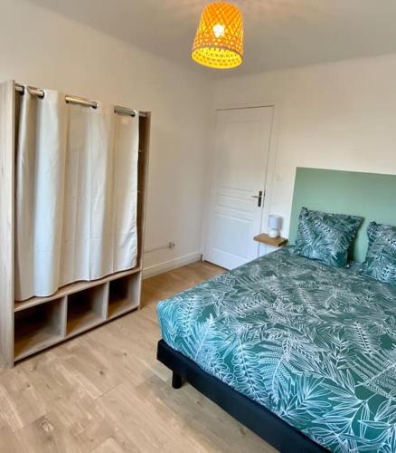 sypialnia z łóżkiem i żyrandolem w obiekcie Vaste Appartement Rénové - Centre Ville w mieście Bourg-en-Bresse