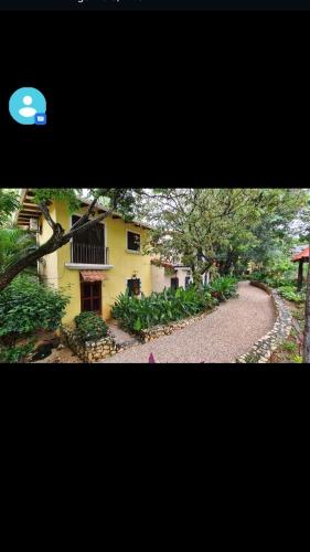a yellow house with a winding road in front of it at Pueblo del mar Tila' s house in Tamarindo