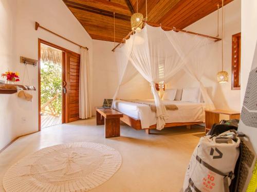 - une chambre avec un lit et un hamac dans l'établissement Vilarejo Preá, à Prea