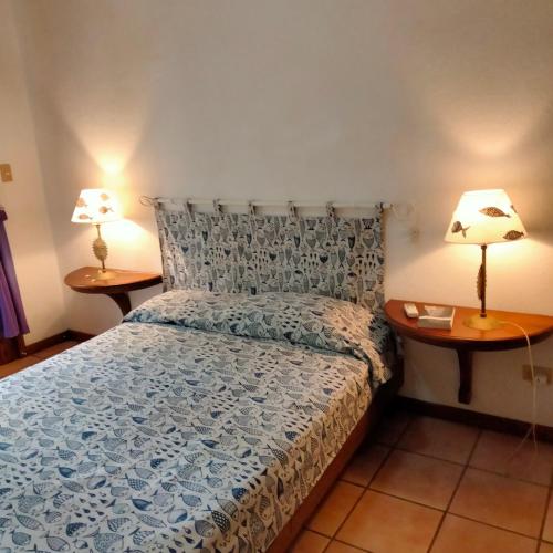 a bedroom with a bed and two lamps on tables at Pueblo del mar Tila' s house in Tamarindo