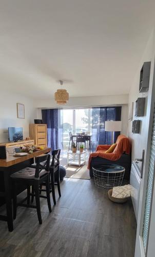 un salon avec une table et une salle à manger dans l'établissement La Voile Bleue où il fait bon être plage et commerces à pied, au Grau-du-Roi