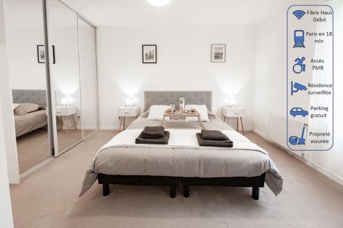 - une chambre avec un grand lit et un grand miroir dans l'établissement Tout confort à Massy - Parking / TGV et RER B&C, à Massy
