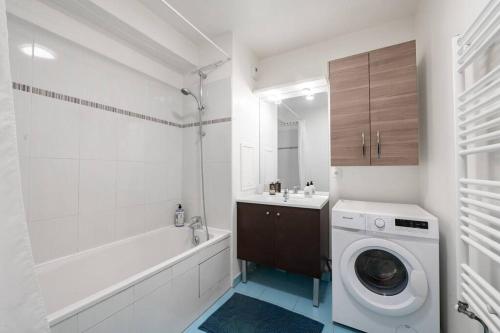 a white bathroom with a washing machine in it at Tout confort à Massy - Parking / TGV et RER B&C in Massy