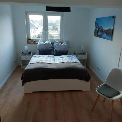 1 dormitorio con 1 cama con 2 mesas y una ventana en Ferienwohnung WESERRATTE, en Hameln