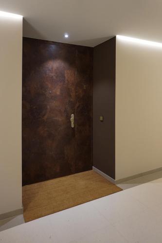 a room with a wooden door and a wall at Schönes Neubau Serviced-Apartment mit Parkplatz in Bruchsal