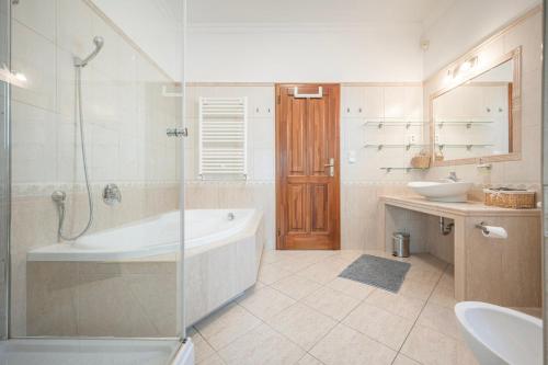 a bathroom with a tub and a sink and a shower at Panorama Buda in Budapest