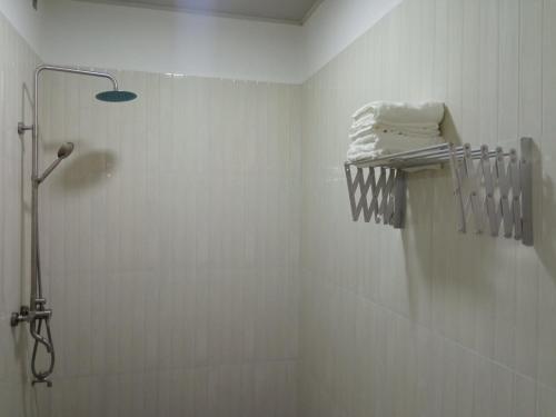 a bathroom with a shower with towels on a rack at Thoddoo Garden inn in Thoddoo