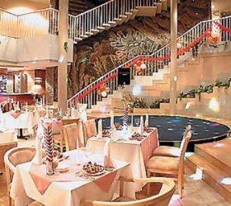 a restaurant with tables and chairs and a staircase at Acfes-Seiyo Hotel in Vladivostok