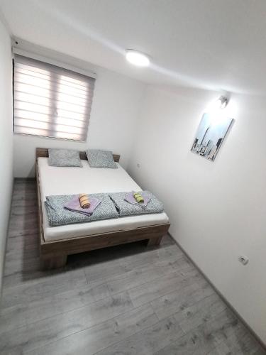 Un dormitorio con una cama con dos pantuflas encima. en Apartman Mata, en Soko Banja