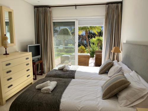 a bedroom with two beds and a large window at ALCAZABA beach in Estepona