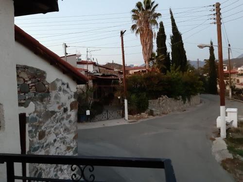 an empty street with palm trees and a building at THE ROCK HOUSE - Beautiful countryside with mandarins oranges and olive trees,. Near Limassol at Eptagonia village. in Ephtagonia