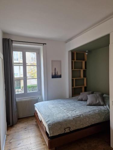 une chambre avec un grand lit et une fenêtre dans l'établissement Appartement 2/4 pers Le Cosy, à Lons-le-Saunier