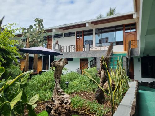 een huis met een balkon en een paraplu bij Fernandina Hotel & Spa in Puerto Ayora