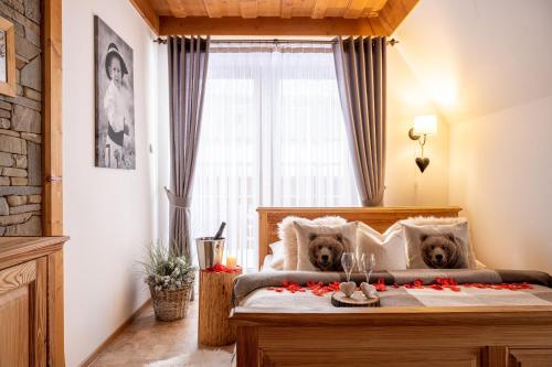 Dois ursos de peluche sentados numa cama num quarto em Willa Mały Dworek em Zakopane