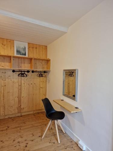 une chaise noire assise sur un bureau dans une pièce dans l'établissement Appartement 2/4 pers Le Cosy, à Lons-le-Saunier