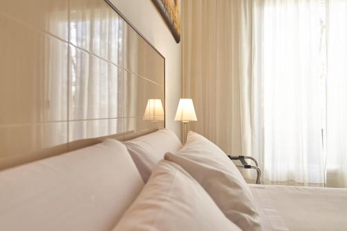 a bedroom with a bed with white pillows and a window at El Hostal de Violeta in Tomelloso