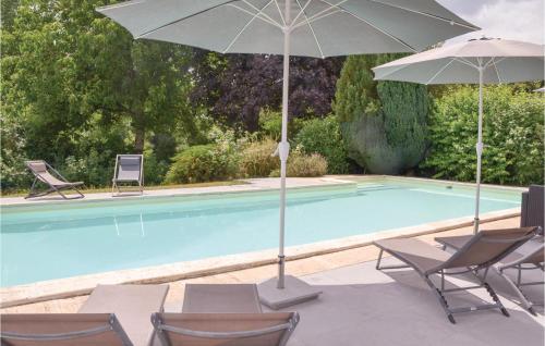 two umbrellas and chairs next to a swimming pool at Beautiful Home In Bouére in Saint-Brice