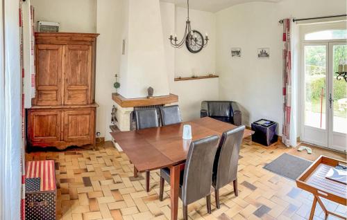 a dining room with a wooden table and chairs at Beautiful Home In Bouére in Saint-Brice