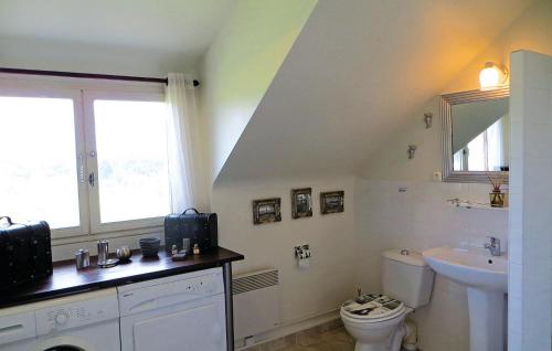 a bathroom with a sink and a toilet and a window at Awesome Home In Boure With 3 Bedrooms, Outdoor Swimming Pool And Heated Swimming Pool in Saint-Brice