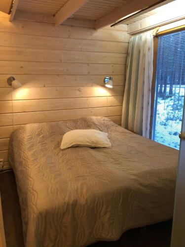 1 dormitorio con 1 cama en una pared de madera en Loma-asunto Kaarna, Kalajärvi, en Peräseinäjoki