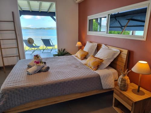 a bedroom with a bed with a view of the ocean at EAST KEYS - Lucy's Bay in Hyacinthe