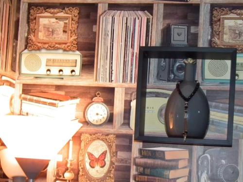 a wall with a shelf with books and a clock at StayHere, Nice Apartment with Garden and sea view, 1 min walk From Beach, High-Speed WI-FI in El Jadida